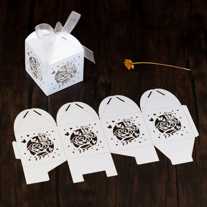 Laser cut white wedding favor box featuring intricate rose and butterfly patterns