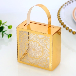Vista de cerca de caja de dulces dorada con diseño de mandala cortado por láser para boda