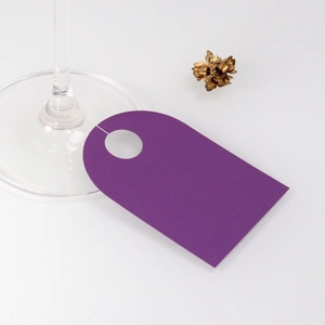 Detailed view of elegant purple paper wine glass card with cutout for event seating