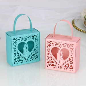 Close-up of laser-cut heart pattern and couple silhouettes on pink and blue gift boxes