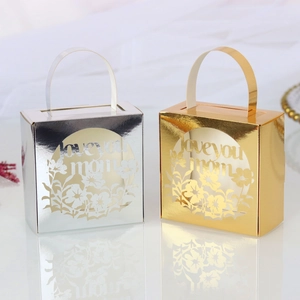 Detail of laser-cut 'Love you mom' gold and silver metallic gift boxes with handles
