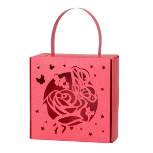 Close-up of red wedding candy box featuring intricate laser-cut rose and butterfly designs