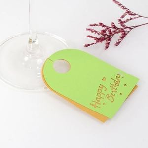 Detalle de tarjetas de copa Happy Birthday verde y oro para decoración de mesa de fiesta