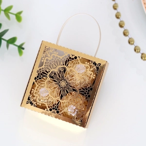 Caja de dulces con encaje de corte láser y patrón hueco dorado con asa de cinta