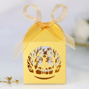 Détail de la boîte à bonbons jaune découpée au laser avec motif élan et ruban doré