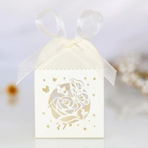 Close-up of laser-cut wedding favor box featuring rose patterns and white silk bow