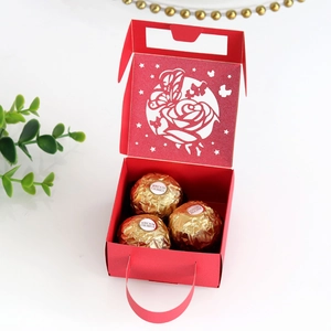 Close-up of laser-cut butterfly and rose pattern on red wedding candy favor box
