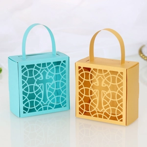 Détail de croix découpée au laser sur des boîtes à bonbons turquoise et dorées