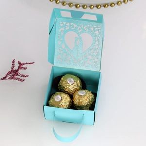 Detail of laser-cut heart pattern on light blue pearlized wedding favor box