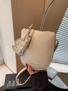 Sacoche selle beige chic avec texture cuir et accessoire de charme chiot mignon