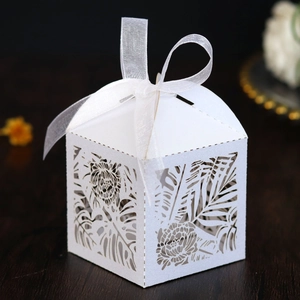 Laser-cut white wedding gift box with tropical leaf patterns and white satin ribbon bow