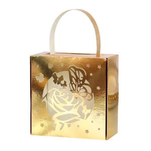 Close-up of golden hollow butterfly and rose patterns on laser-cut wedding candy box