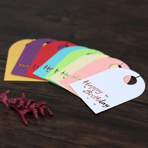 Primer plano de tarjetas caladas Happy Birthday de colores sobre mesa de madera oscura