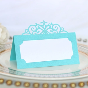 Detail of laser-cut place card with scroll pattern on a gold-rimmed decorative plate