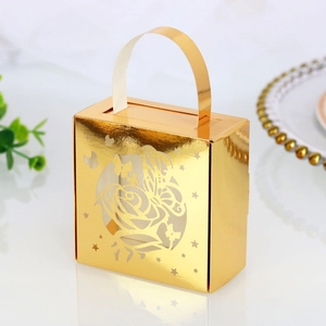 Close-up of golden laser-cut gift box featuring intricate rose and butterfly patterns