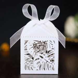 Macro detail of laser-cut tropical leaf patterns on a white pearlescent paper gift box