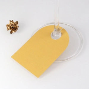 Macro shot of gold wedding place cards on wine glass stem for party table decor