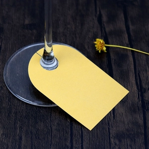 Close-up of golden glitter glass place card on wine glass stem for wedding table décor