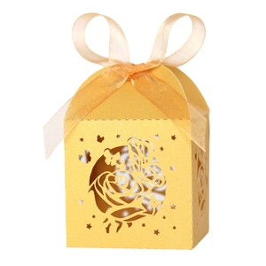 Elegant gold laser-cut wedding candy box with rose and butterfly patterns and a ribbon