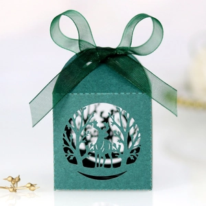 Détail du motif d'élan découpé au laser sur boîte cadeau vert foncé avec ruban satin