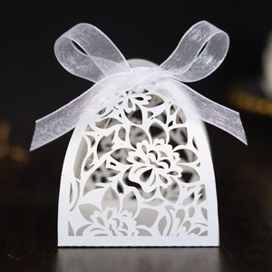 Close-up of laser-cut flower patterns on white pearlescent wedding favor gift box
