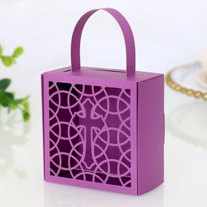 Détail du motif de croix découpé au laser sur une boîte cadeau violette avec anse