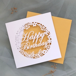 Detail of laser-cut white Happy Birthday card with intricate butterfly and flower motifs