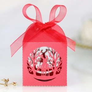 Détail de boîte à bonbons rouge découpée au laser avec motif cerf et ruban organza