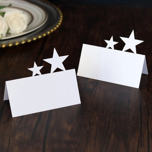 Detailed view of white laser-cut star place cards on a rustic wooden table setting