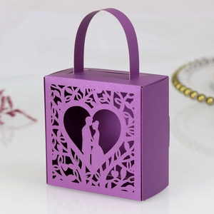 Detail of purple laser-cut wedding candy box with romantic couple silhouette and handle