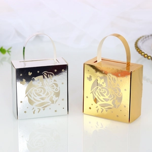 Detail of laser-cut butterfly and rose patterns on gold and silver wedding favor boxes