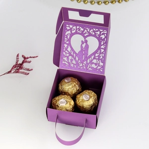 Detail of purple laser-cut gift box with heart silhouettes and chocolate inside