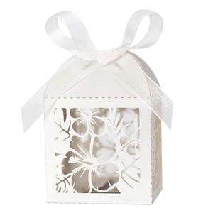 Detailed laser-cut tropical leaf patterns on a white wedding favor box with ribbon bow
