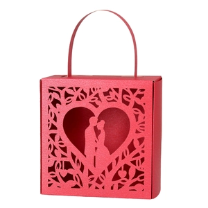Detail of red laser-cut wedding candy box featuring a heart silhouette and couple motif