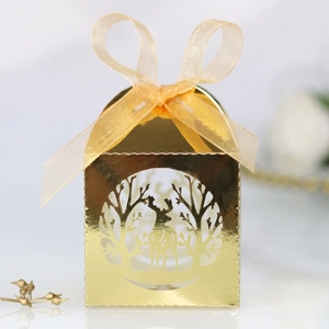 Détail du motif de renne découpé au laser sur une boîte cadeau dorée avec ruban