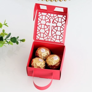 Détail de la boîte cadeau rouge avec motif croix et poignée pour dragées de mariage