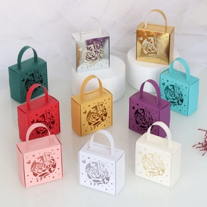 Detailed laser-cut wedding favor boxes in various colors with butterfly and rose patterns
