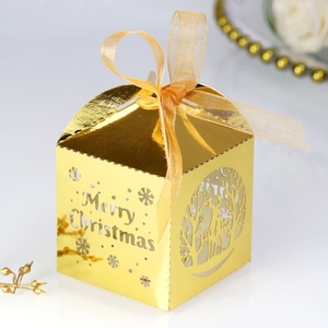 Détail d'une boîte à bonbons dorée de Noël découpée au laser avec flocons et rennes évidés