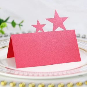 Close-up of red pearlescent star hollow place card on a decorative plate for events