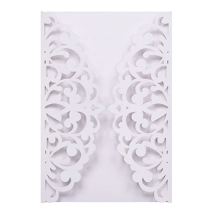Detail of white laser cut wedding invitation featuring elegant hollow floral patterns