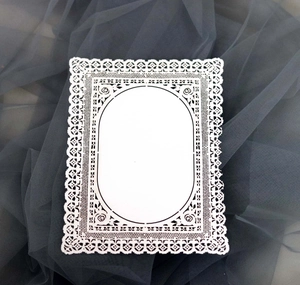 Dettaglio di carta decorativa in pizzo tagliata al laser con motivi floreali bianchi
