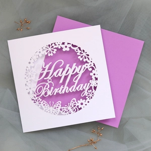 Intricate laser-cut white birthday card with Happy Birthday text and lavender envelope