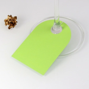 Detail view of light green arched paper wine glass place cards for wedding seating