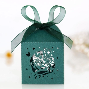 Detail of dark green laser-cut wedding candy box with rose and butterfly patterns