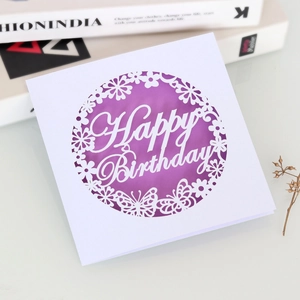 Close-up of laser-cut purple butterfly birthday card with intricate hollow floral patterns