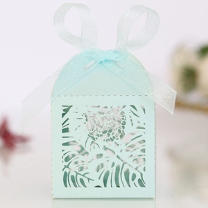 Detailed laser-cut mint green wedding favor box with leaf pattern and silk ribbon