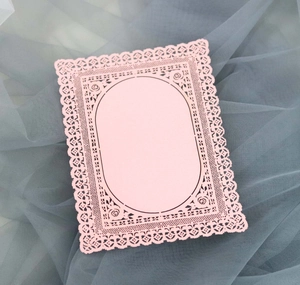 Dettaglio della carta rosa tagliata al laser con intricati motivi floreali