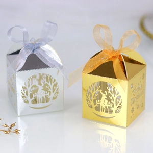 Détail d'une boîte à bonbons de Noël découpée au laser avec motifs de renne et rubans