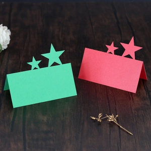 Macro detail of red and green star-shaped hollow table cards with pearlescent finish