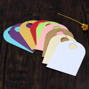 Close-up of multicolored wedding place cards with U-shaped hook on wooden surface